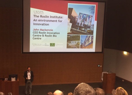 Photograph of John Mackenzie, CEO of Roslin Innovation Centre, presenting on stage at UKSPA Conference hosted in Midlothian 
