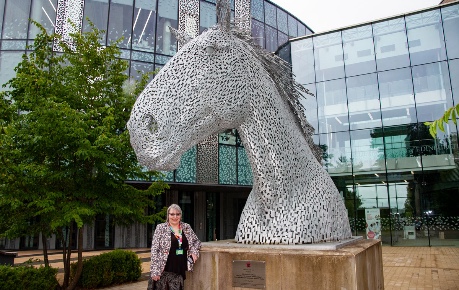 Photo of Val Hughes-White, Director of Roslin Innovation Centre standing beside the Canter statue on Easter Bush Campus